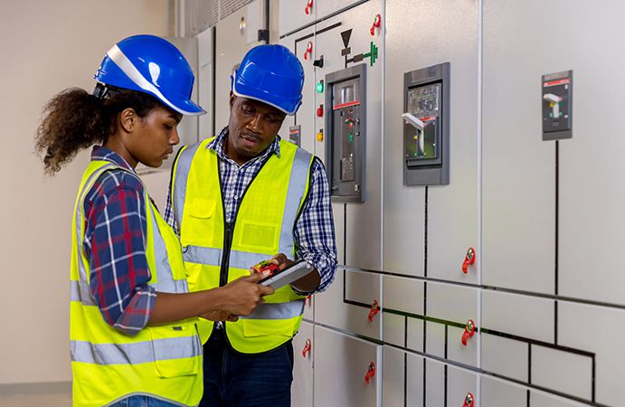 Two engineers looking at a panel